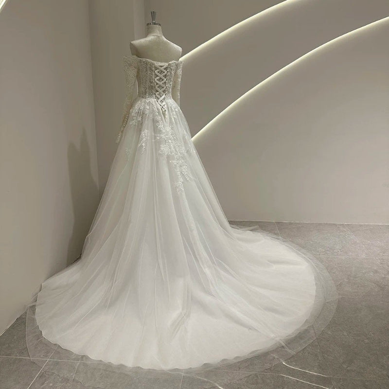 Ivory lace wedding dress with lace-up corset back and long flowing tulle skirt