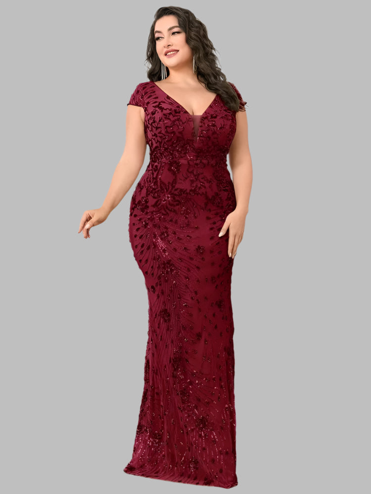 A model wearing a burgundy sequin evening formal dress. It has a v-neck cap sleeves and is floor length