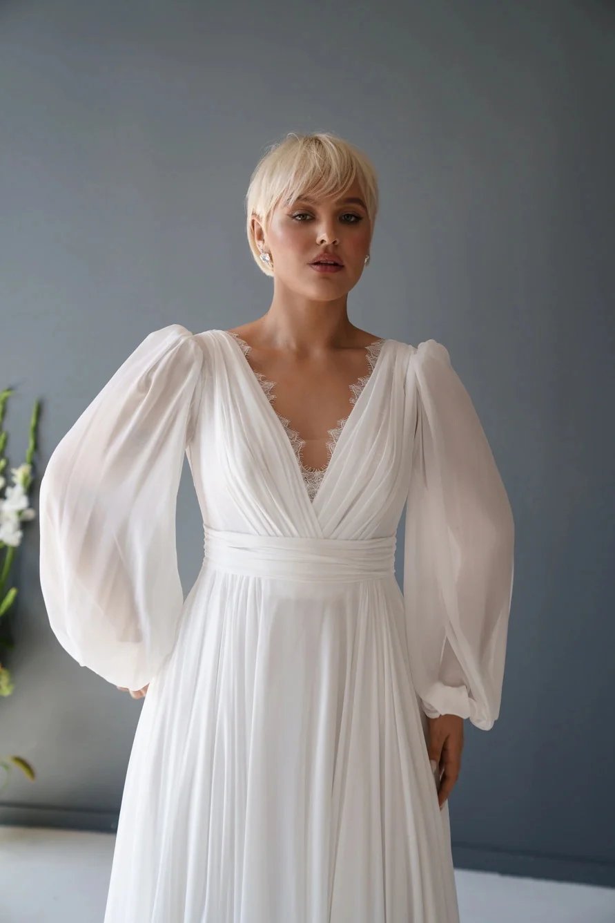 Long puff sleeves with a decorative eyelash lace v-neck. Chiffon wedding dresses in white or ivory