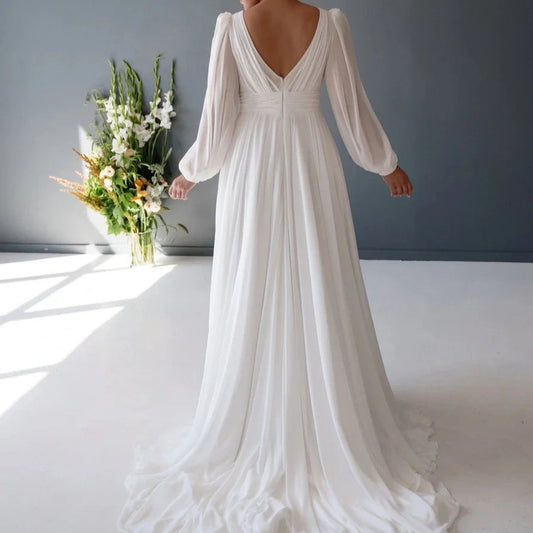 White chiffon V-neck wedding dress with gathered bodice, billowy puff sleeves, long skirt
