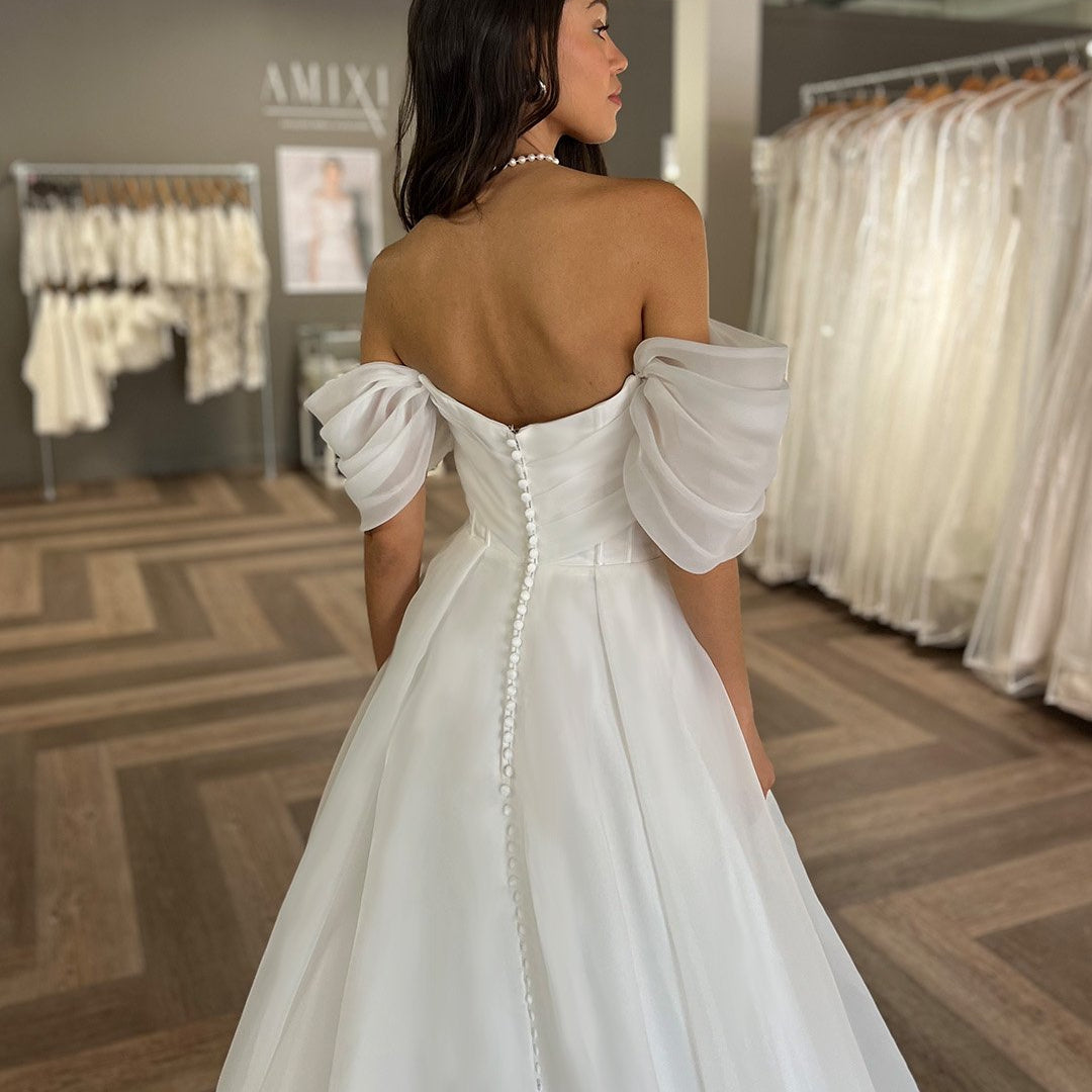 backless wedding dress in white or ivory organza with covered button detail the length of the back and train