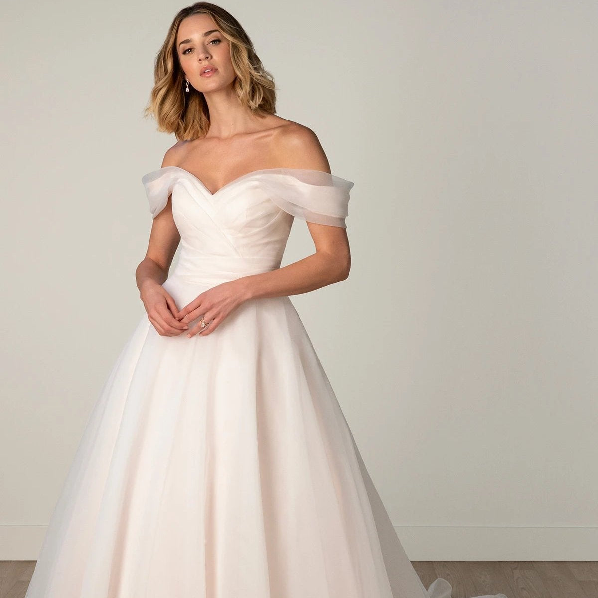 Pink organza a-line style with an off the shoulder pleated bodice. All sizes 2-26w available