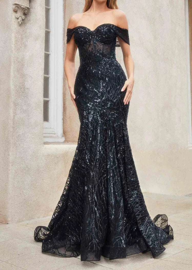 A woman in a black mermaid-style evening dress with glitter sequins, an off-the-shoulder neckline, and a sweep train