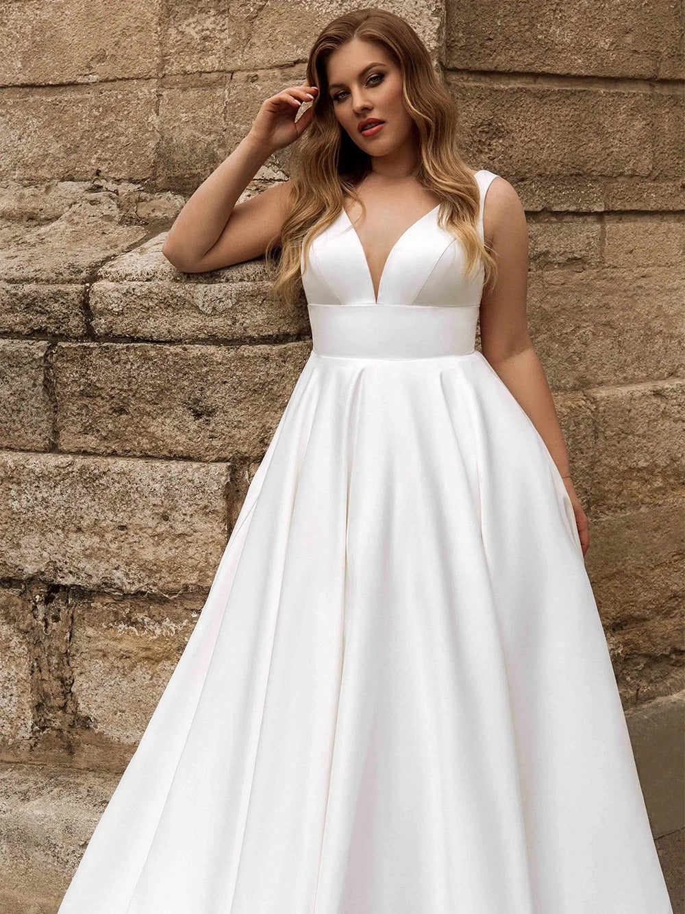 white satin v-neckline sleeveless with a v shaped back wedding dress. With side pockets and a beautiful sweep train bridal gown.