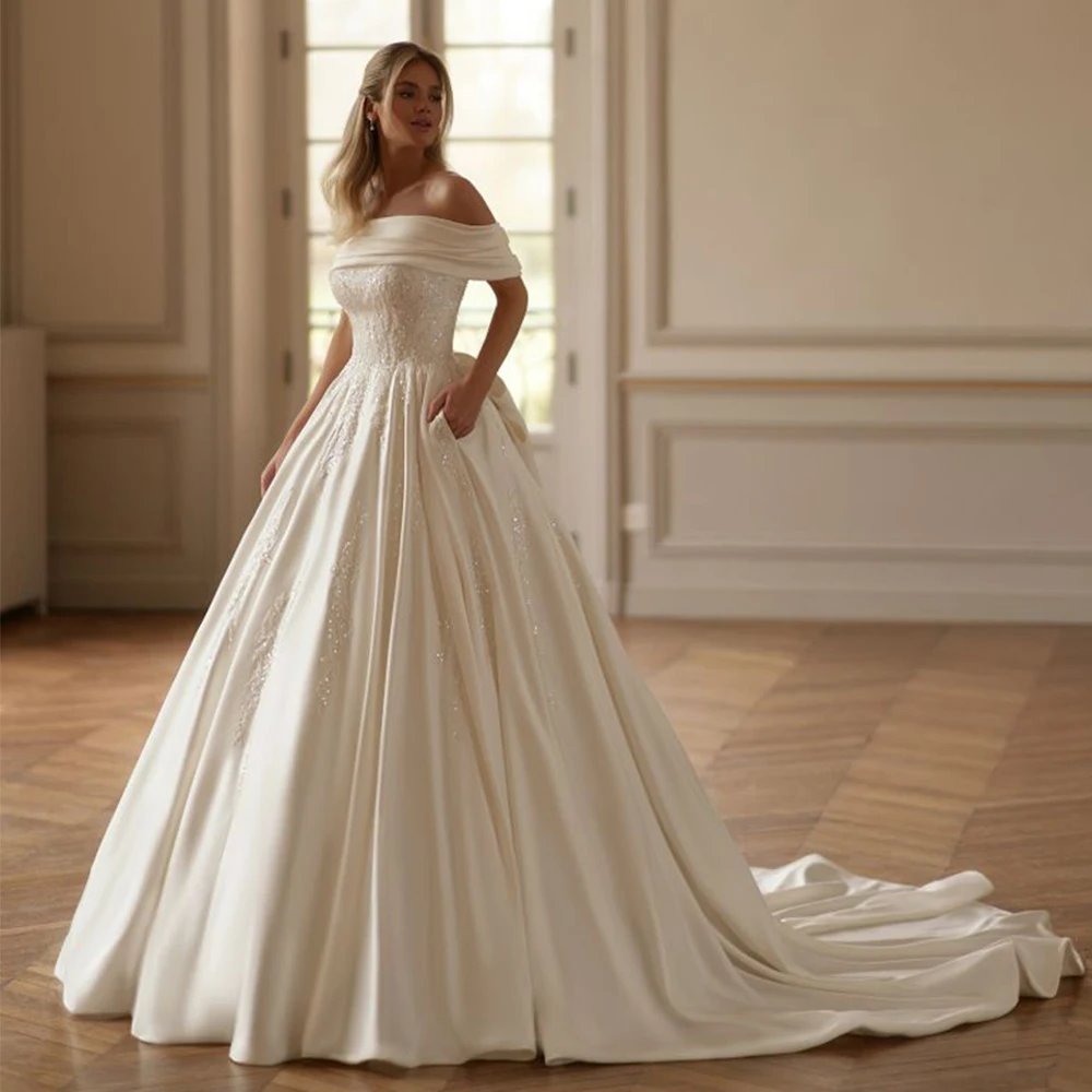 Ivory satin off the shoulders princess bridal gown. Beautifully embellished with pearls and beading on the bodice.