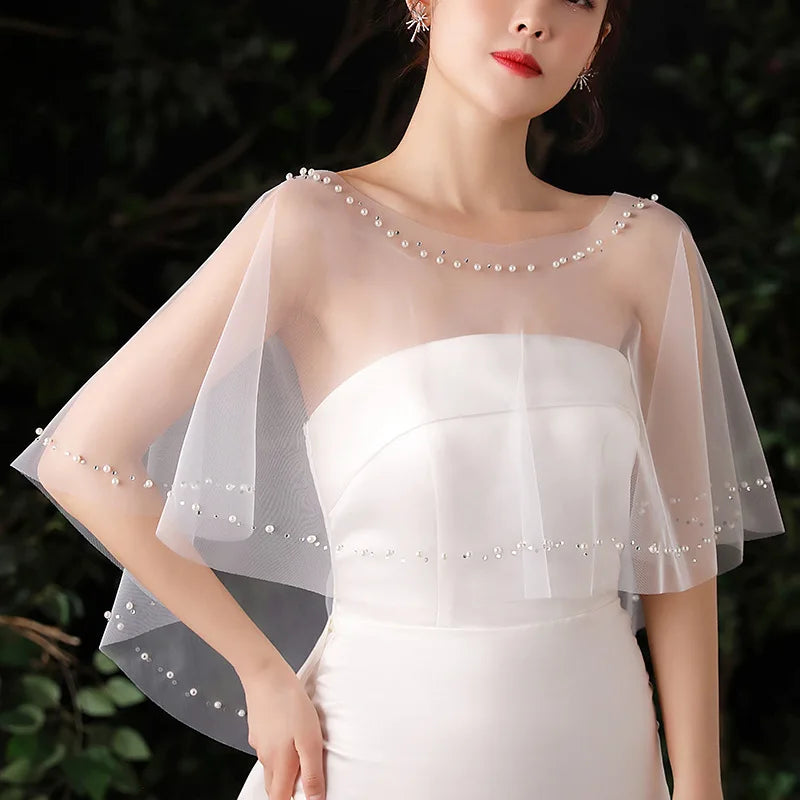 Ivory beaded bridal cape shrug with draped sheer sleeves and pearl bead neckline row