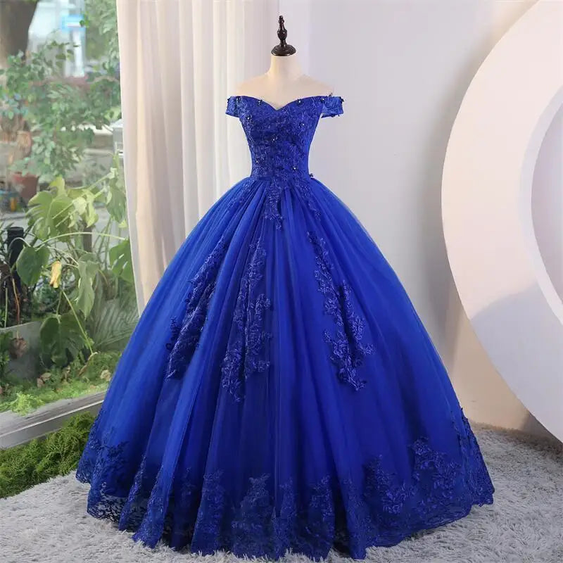 A royal blue off-the-shoulder applique lace luxury ball gown with a natural waistline and lace-up back on a mannequin.