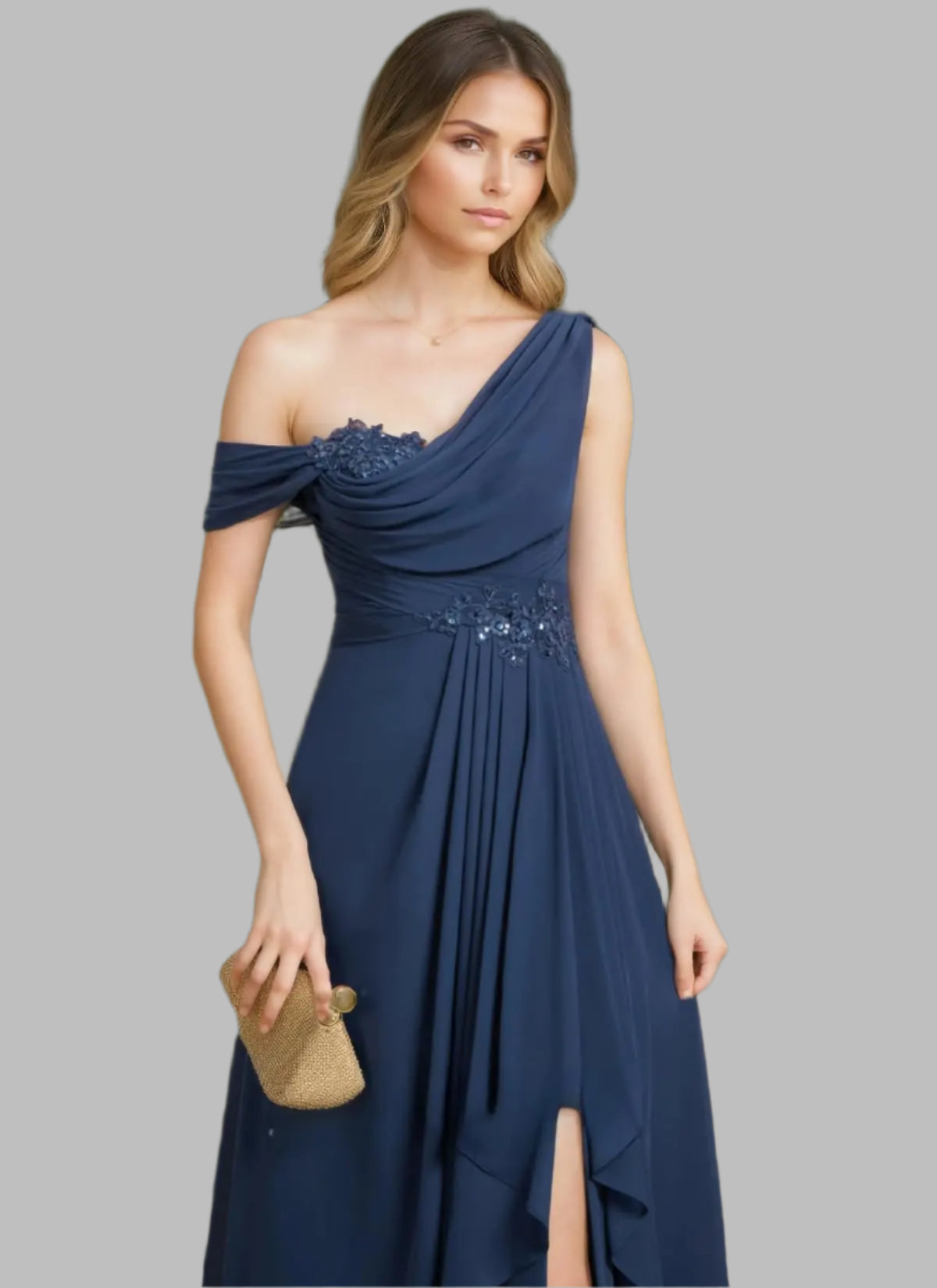 Woman in a navy blue one-shoulder dress with floral embellishments against a green leafy background.