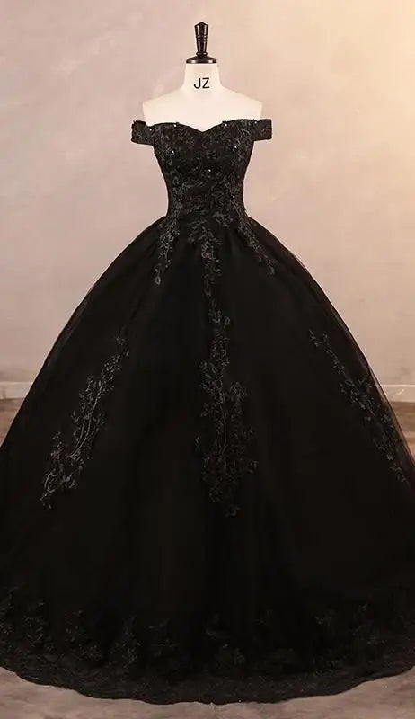 A black off-the-shoulder applique lace luxury ball gown with a natural waistline and lace-up back on a mannequin.