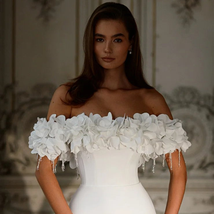 White off-shoulder wedding dress bodice with layered floral neckline and beaded sleeve drops