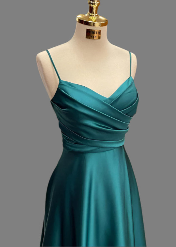Teal dress on a mannequin against a gray background