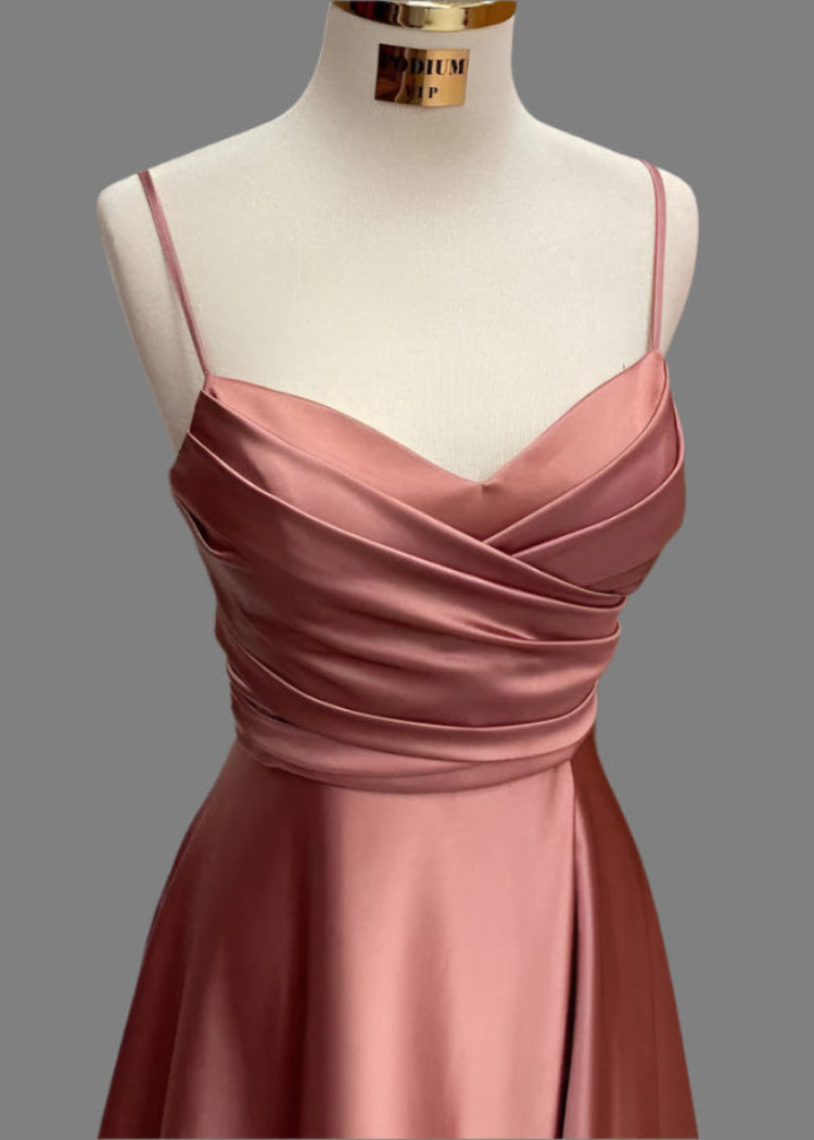 Pink satin dress on a mannequin against a gray background