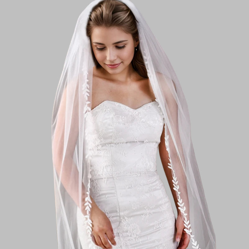 White cathedral wedding veil with lace-trimmed edge, worn over bridal hair