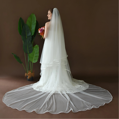 White cathedral-length bridal veil with satin-edged border and flowing tulle layers