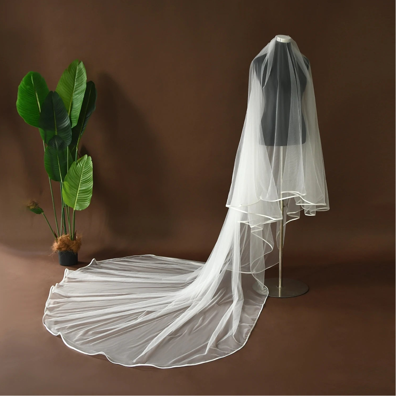 White cathedral-length bridal veil on mannequin with long layered tulle and satin edge