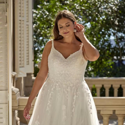 Ivory bridal gown with V-neck, sequined lace bodice, and tulle sleeves