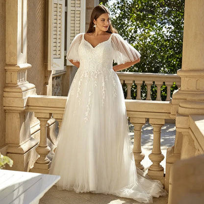 Ivory bridal gown with V-neck, sequined bodice, and detachable tulle sleeves