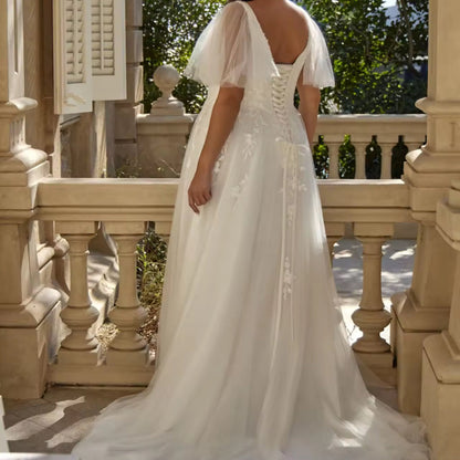 Ivory A-line bridal gown with V-back detail, sequined bodice, and tulle sleeves