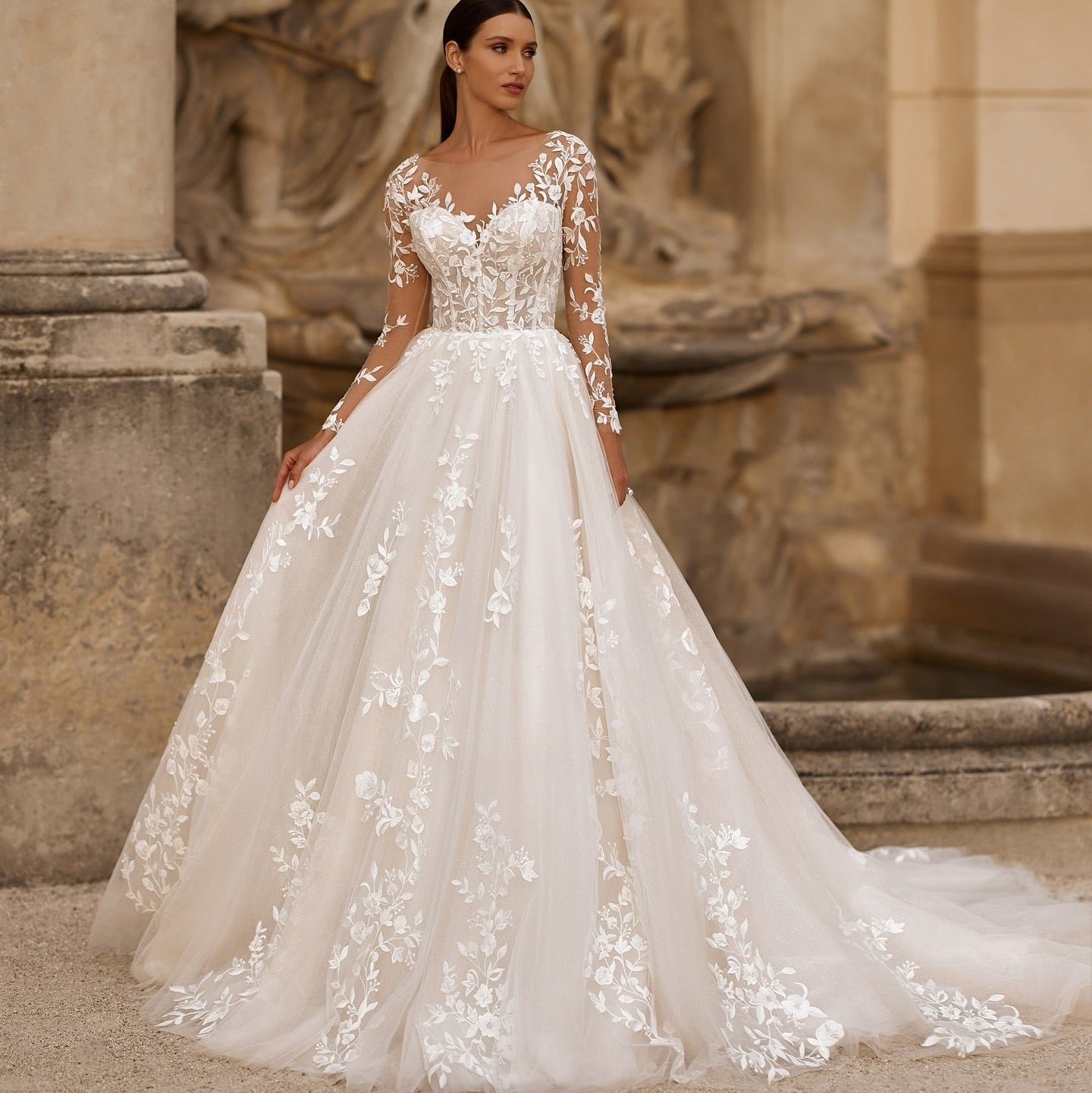 White illusion lace wedding dress with long sleeves, floral appliqué bodice, full skirt