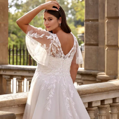Ivory A-line lace wedding dress with V-neckline and floral appliqué on the bodice