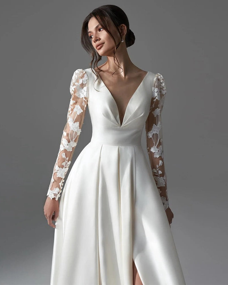 Ivory satin wedding dress with deep V neckline, lace long sleeves, and pleated skirt