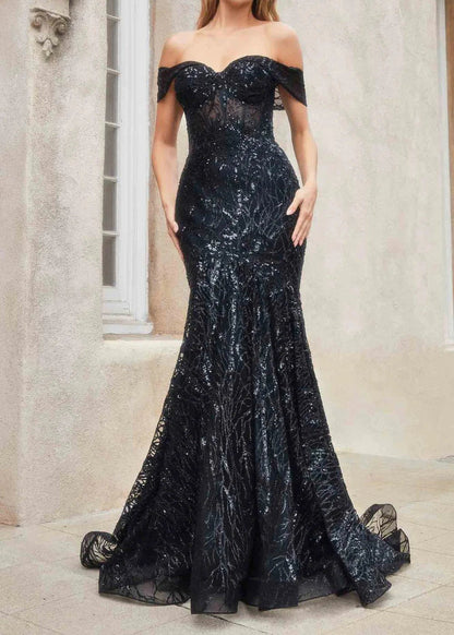A woman in a black mermaid-style evening dress with glitter sequins, an off-the-shoulder neckline, and a sweep train