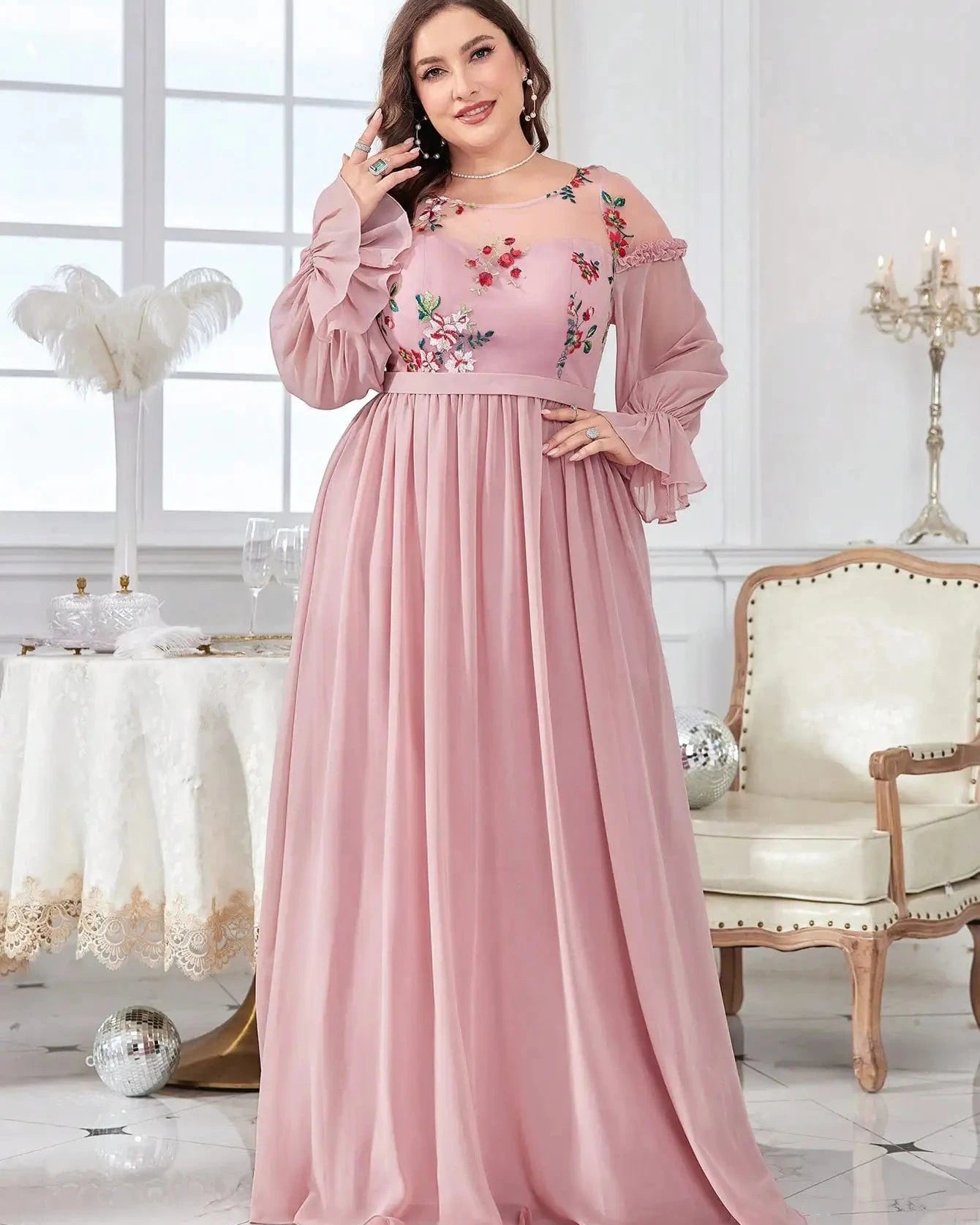 Pink chiffon evening dress with floral embroidery and long ruffle sleeves, flowing pleated hem.
