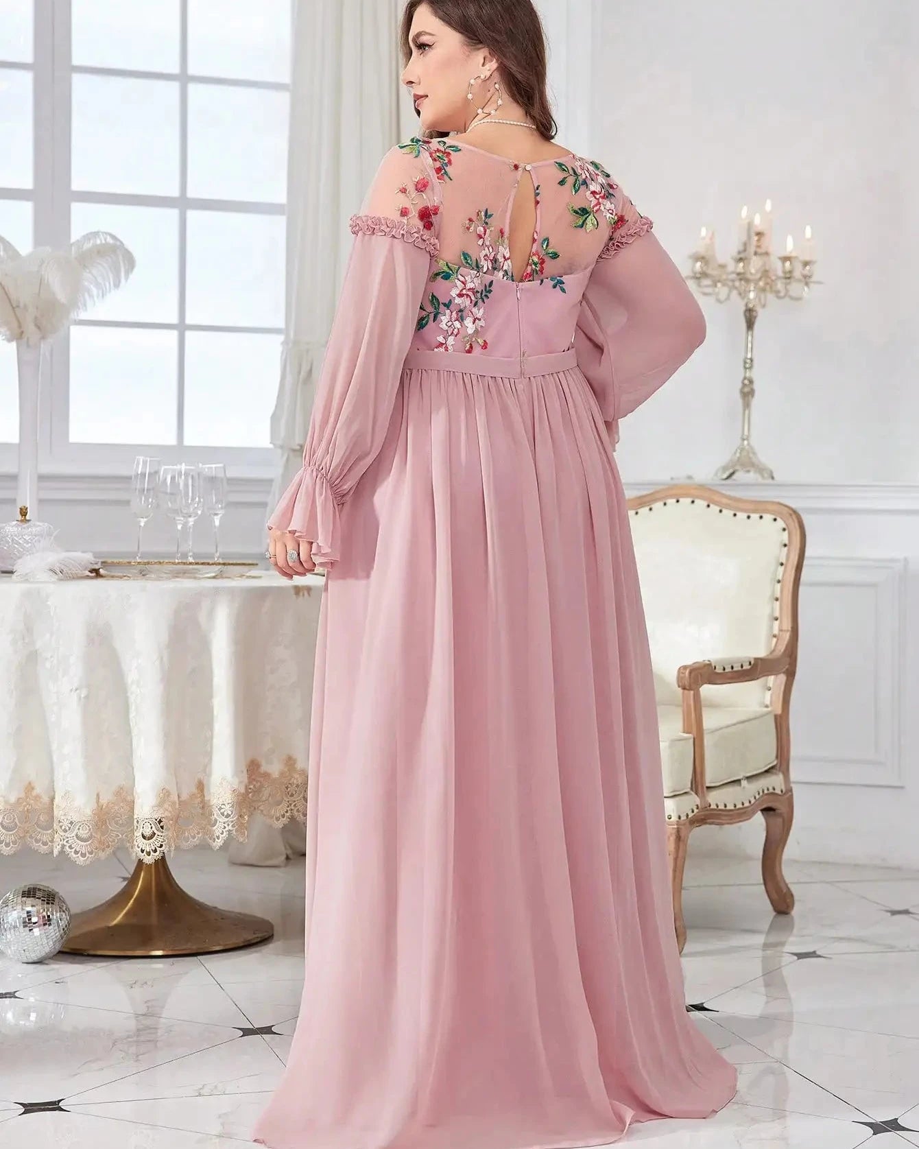 Pink chiffon evening dress back view with floral embroidery, long sleeves and pleated skirt.
