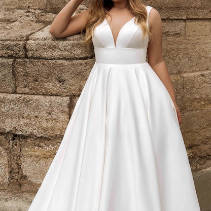 White satin sleeveless wedding dress, deep V-neck bodice, gathered waist, full skirt.