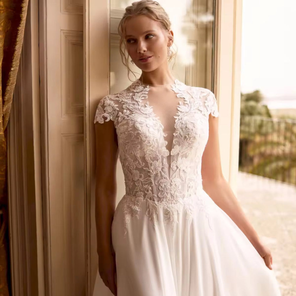 Ivory chiffon wedding dress with lace cap sleeves and fitted bodice, pleated skirt