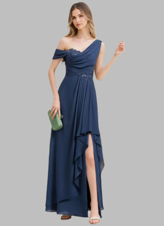 Woman wearing a blue off-shoulder dress with a slit, holding a green clutch, against a white background with greenery.