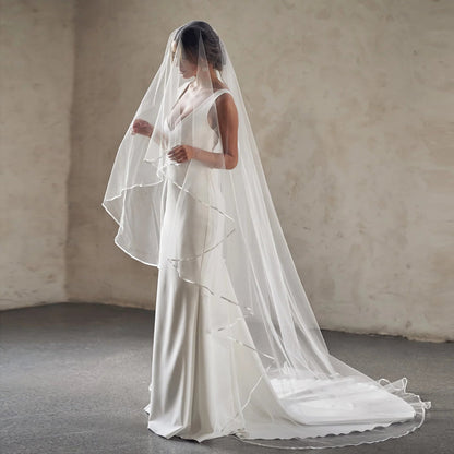 White two-tier cathedral wedding veil with sheer tulle layers and straight-edged trim