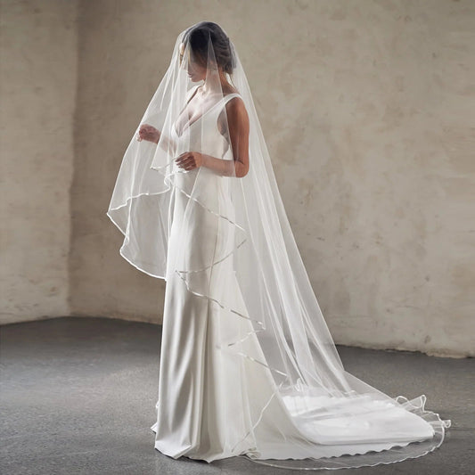 White two-tier cathedral wedding veil with sheer tulle layers and straight-edged trim