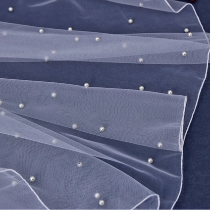 Elbow-length veil with dark tulle layers and small pearl-like bead details along edge