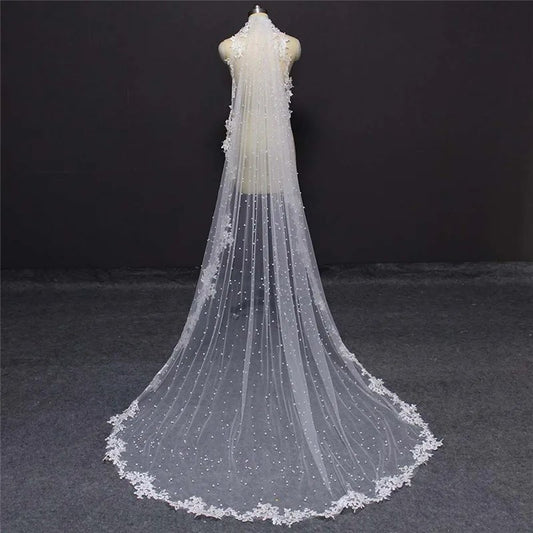 White or ivory one layer wedding veil. Made of quality soft tulle and decorated with pearls and lace edge